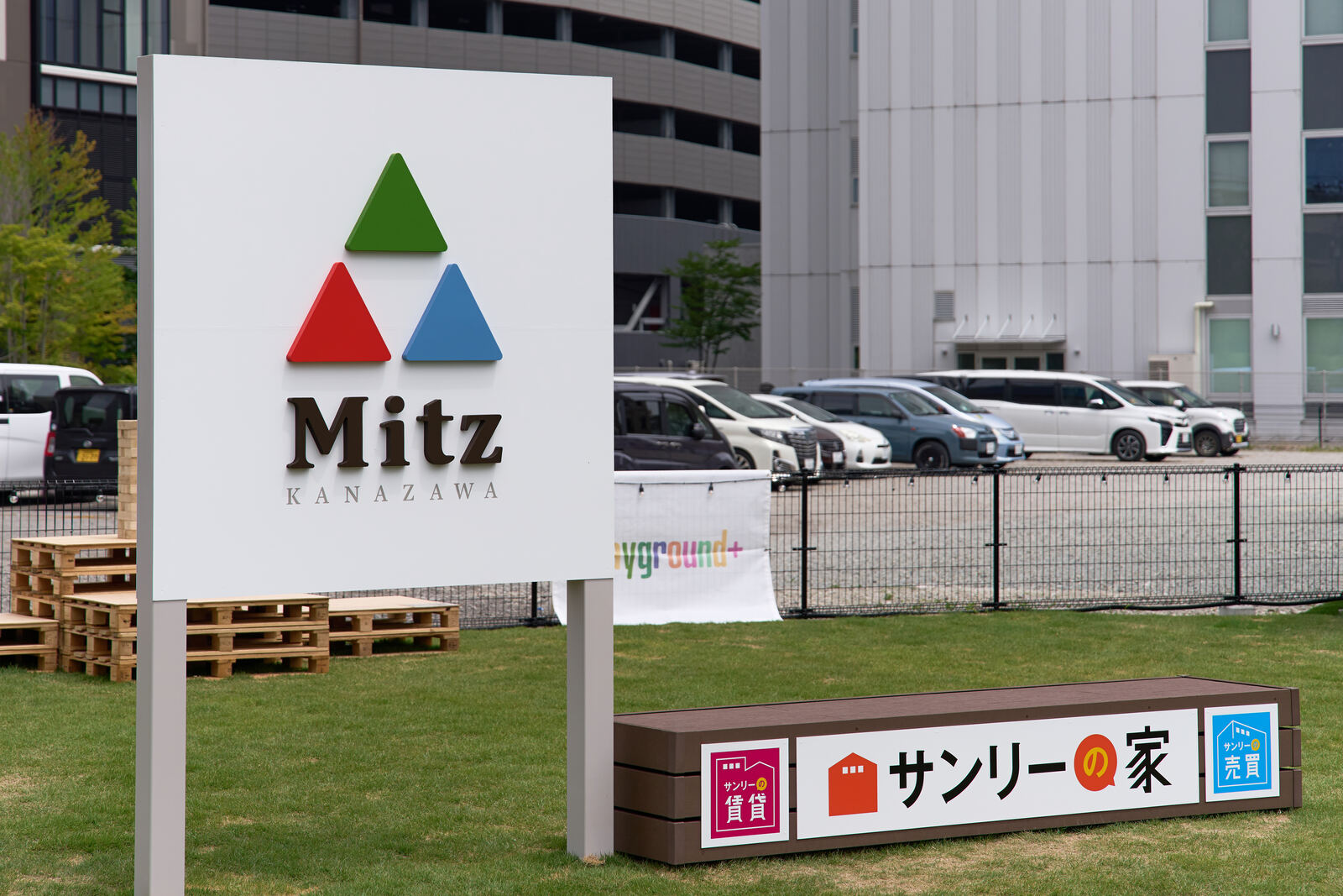 芝生の広場に立つMitz金沢のサインボード